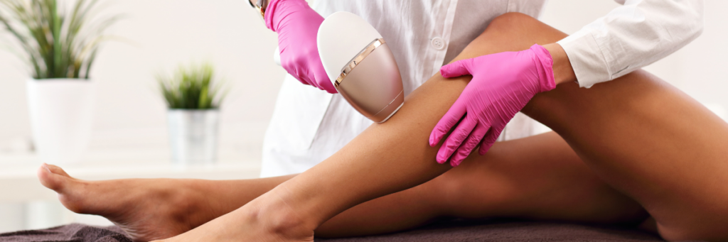 Laser Hair Reduction: What to Expect & How It Works – Bloom MedAesthetics Close up of a woman's legs getting laser hair removal by a doctor wearing pink latex gloves and a white coat