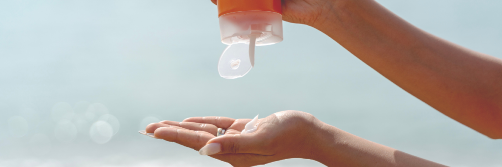 A close up of someones hands as the squeeze sunscreen into them.