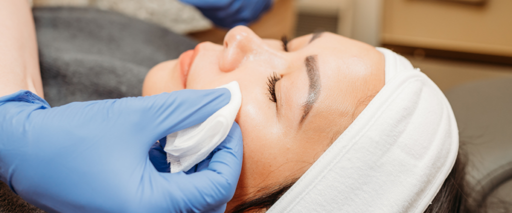 The Top Holiday Treatments for Your Skin – Bloom MedAesthetics Woman laying down with her eyes closed getting a skin treatment done for the holidays