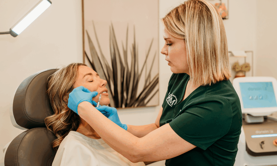 Licensed aesthetic nurse performing dermal filler injection on patient for a quick aesthetic treatment before the holidays at BLOOM MedAesthetics clinic.