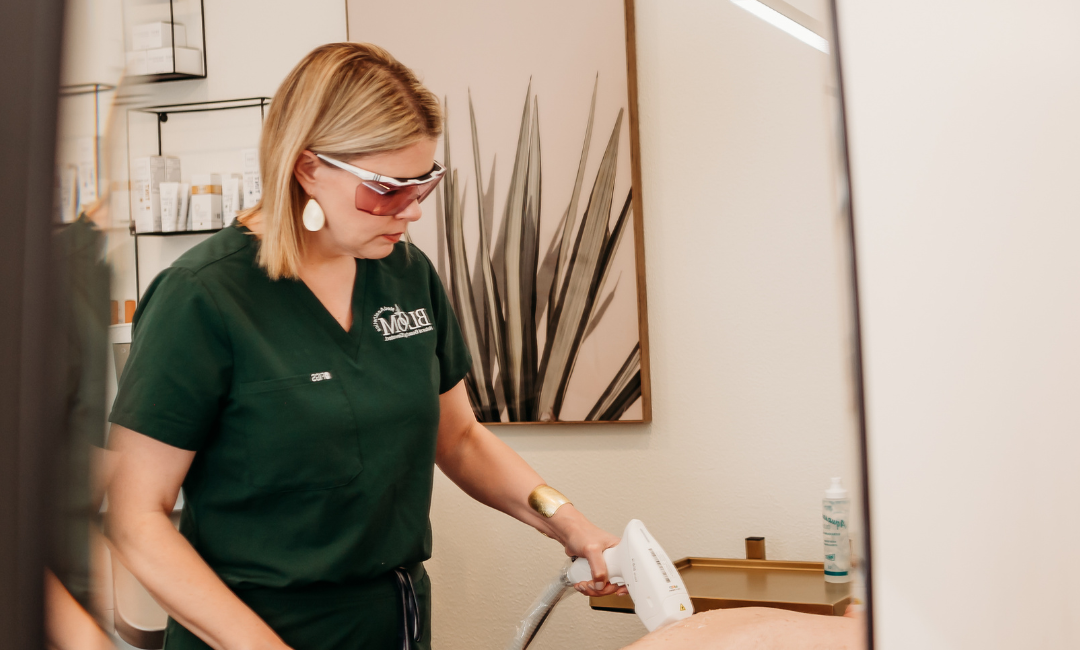 Bridget from Bloom MedAesthetics performing laser hair removal on a man's back