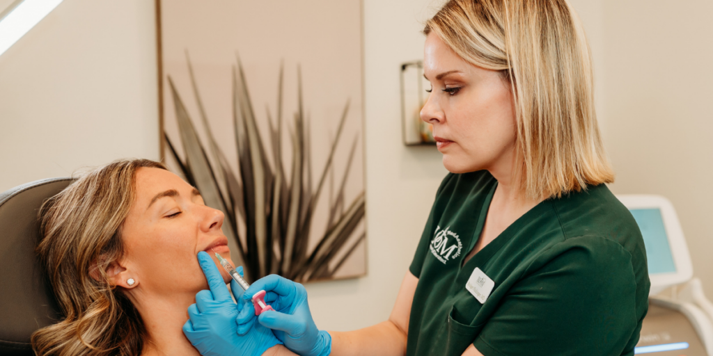 Medical aesthetic provider performing lip filler injections on a patient during a cosmetic treatment consultation at a luxury med spa clinic with a new state college location.